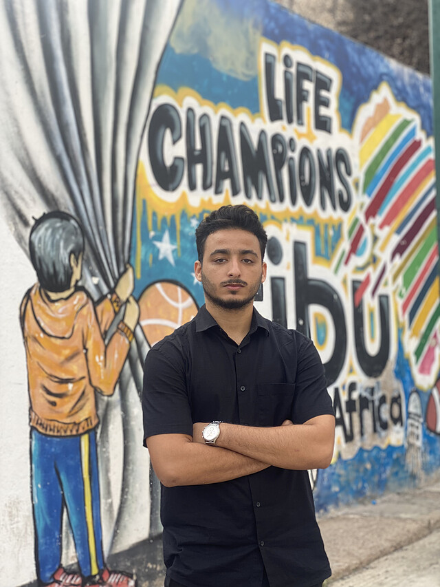 Mohamed-Amine at a street art mural
